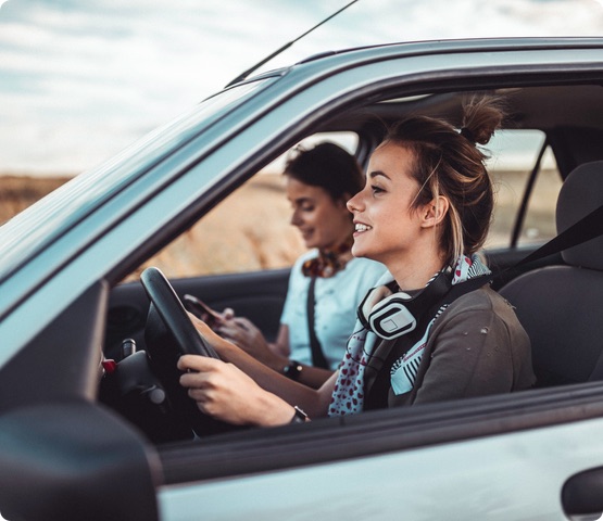 Person drives with friend in passenger seat. Young drivers insurance