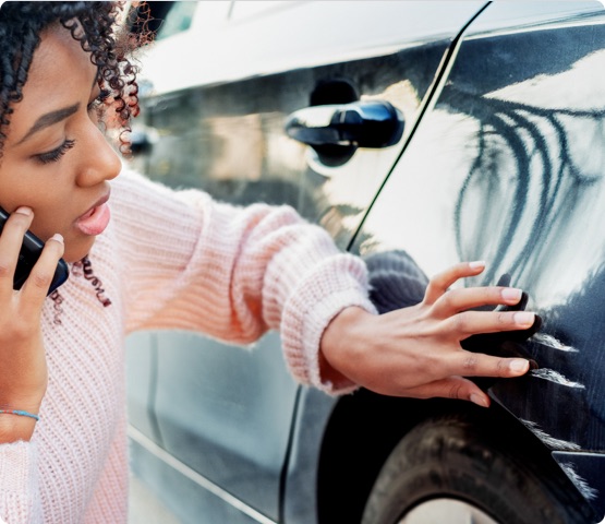 Person looks at large scratches on outside of car